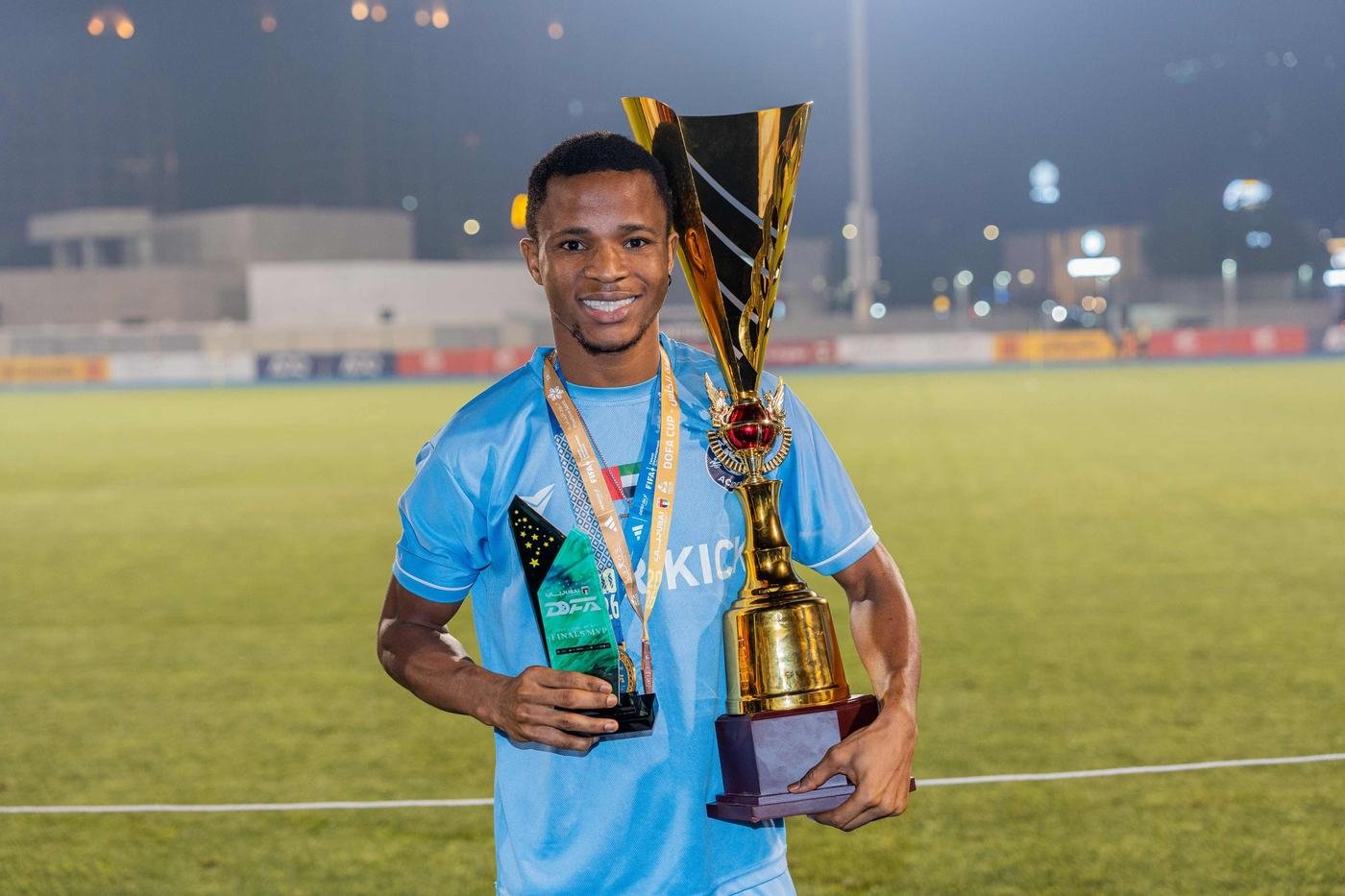 Player holding a cup and an award