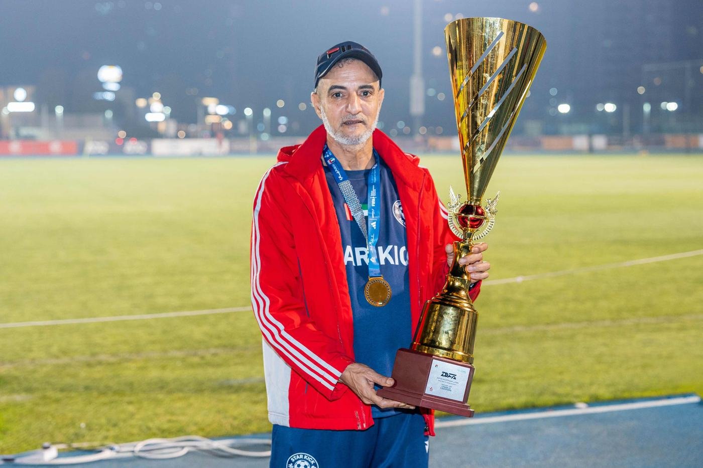 Coach holding a trophy and an award